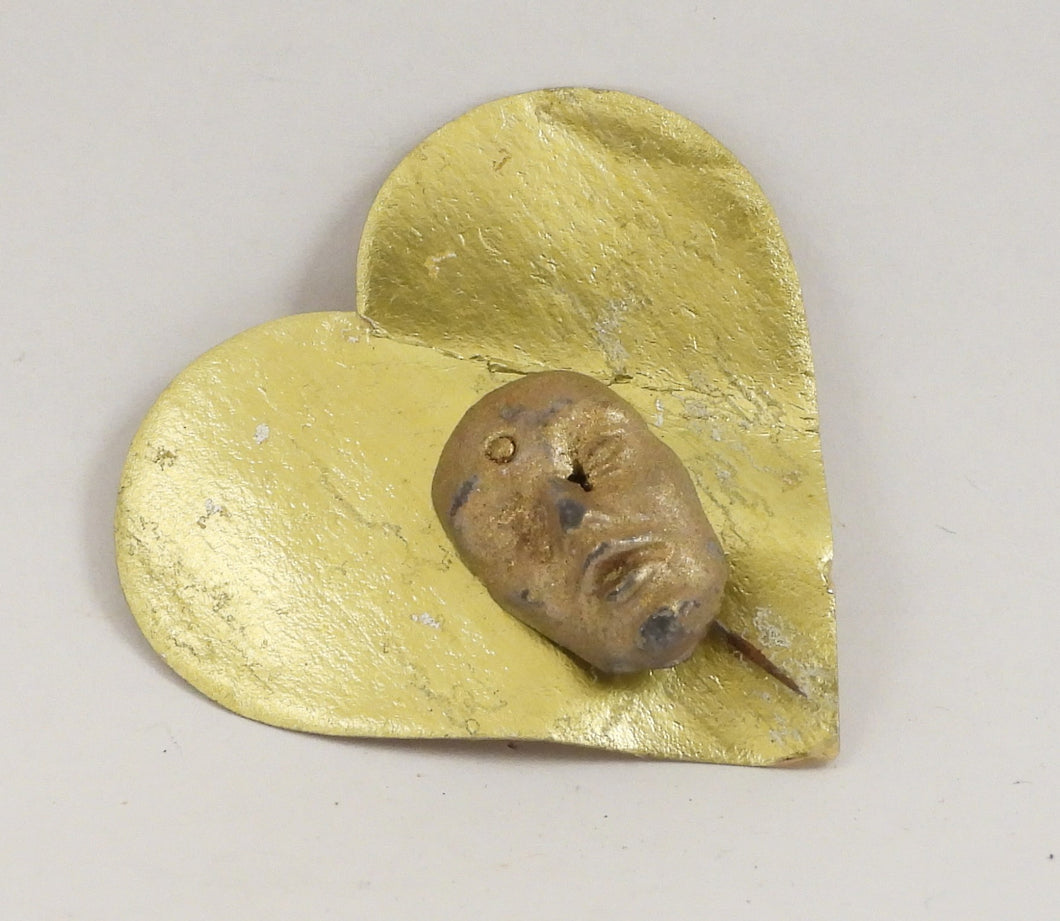 Pins med guldfarvet ansigt