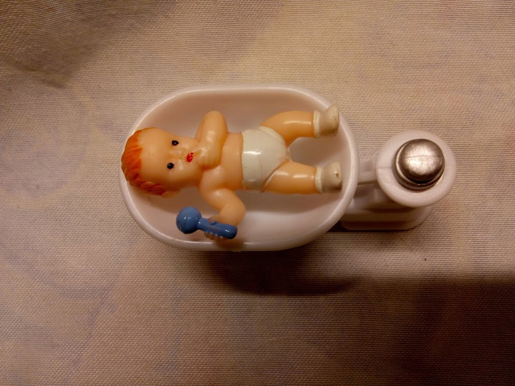 Kagefigur barnedåb baby i vægt med rangle